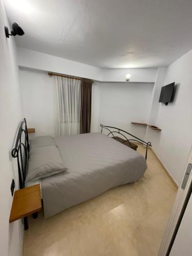 Un pequeño dormitorio con una cama y un televisor. en Izvor apartament, en Borsa