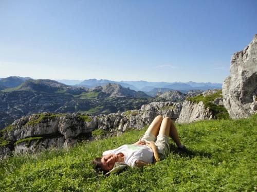 a woman laying in the grass on a mountain at Ausseer Kleeblatt in Bad Aussee