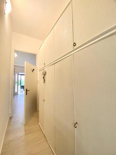 a hallway with white cabinets and a door at DolceMare - Apartment in Lido di Jesolo