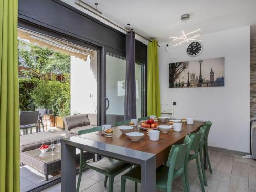 a dining room with a wooden table and green chairs at Holiday Home Sol Cambrils Park 28 by Interhome in Cambrils