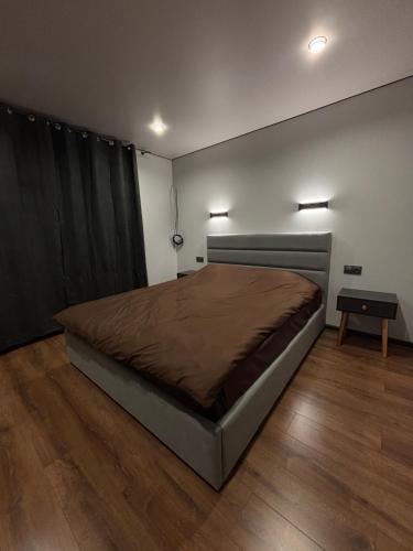 a bedroom with a large bed and a wooden floor at ChillVille in Ternopilʼ