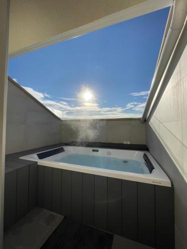 a jacuzzi tub in a room with a window at Hostal Restaurante Ibaisek in Zudaire