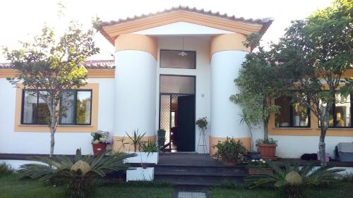 a white house with trees in front of it at Vivenda Cinco Reis in Angra do Heroísmo
