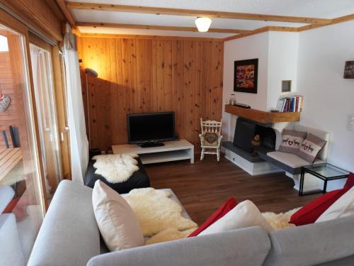 a living room with a couch and a tv at Apartment Hyacinthe 14 by Interhome in Villars-sur-Ollon
