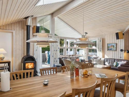 una sala da pranzo con tavolo e camino di Holiday Home Tyyne - 250m from the sea by Interhome a Tjørneholm