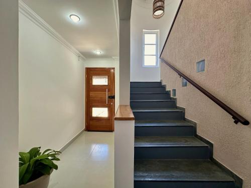 a staircase with blue steps and a wooden door at Mar de Corais Hospedagem in Serra