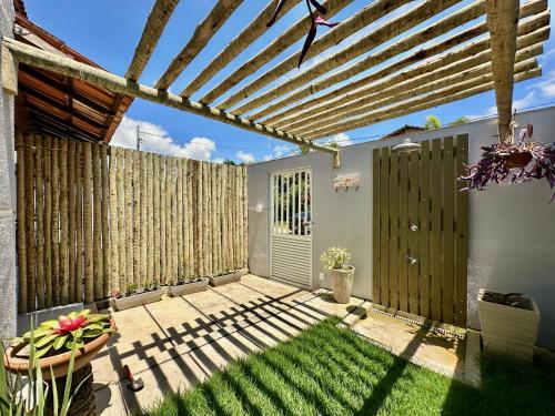 a patio with a fence and a wooden pergola at Mar de Corais Hospedagem in Serra