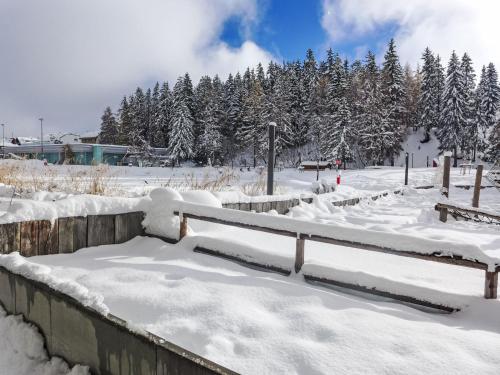 a snow covered park with trees in the background at Apartment Central Parc 2 by Interhome in Crans-Montana