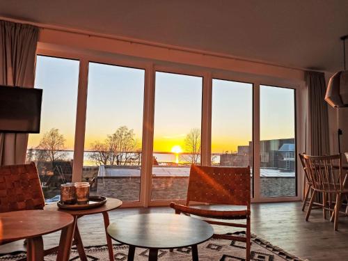 a living room with a view of the sunset at Apartment Penthouse Seeblick by Interhome in Lembruch