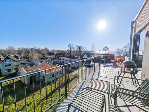 a balcony with two green chairs on a building at Apartment Penthouse Seeblick by Interhome in Lembruch