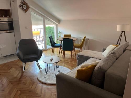 un soggiorno con un divano e un tavolo con sedie di MD apartman Vranje FREE PARKING a Vranje
