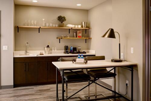 a kitchen with a table and a counter top at Archer Hotel Boston/Burlington in Burlington