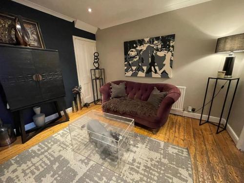 a living room with a couch and a glass table at The Little Boutique House in Byfleet
