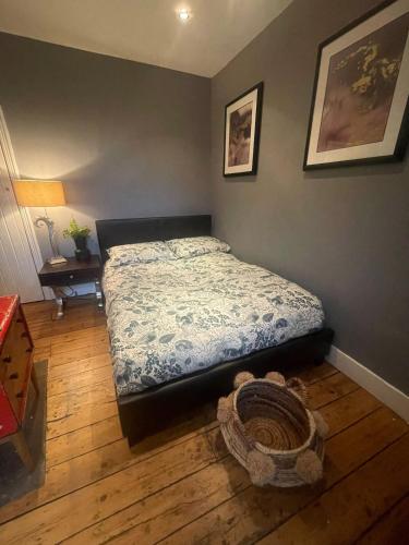 a bedroom with a bed and a table with a lamp at The Little Boutique House in Byfleet