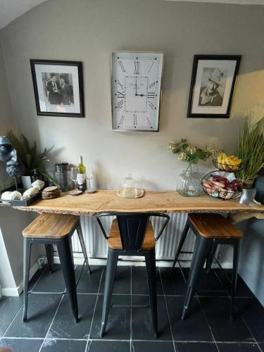 a wooden table with chairs in a room at The Little Boutique House in Byfleet