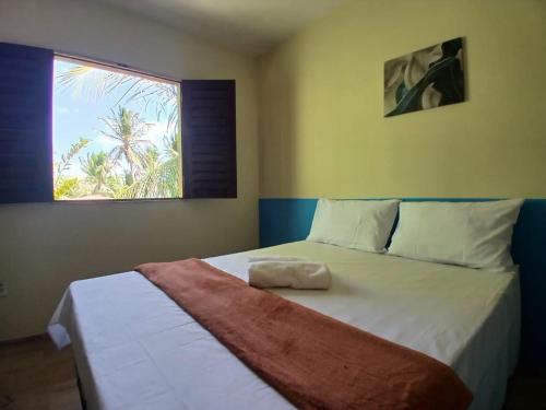 ein Schlafzimmer mit einem großen Bett mit Fenster in der Unterkunft Koral House - GURIÚ in Camocim