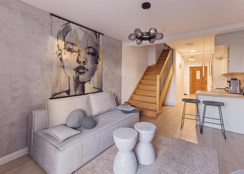 a living room with a couch and a painting on the wall at Urban Nest in Szczecinek