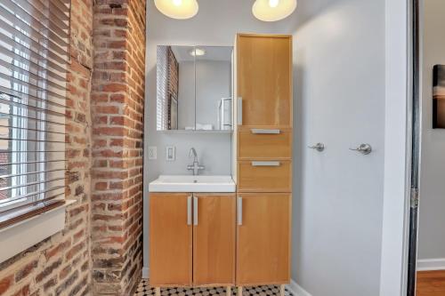 a bathroom with a sink and a brick wall at Home at 1014 in Savannah