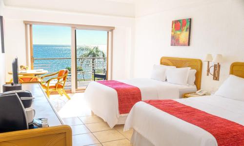 ein Hotelzimmer mit zwei Betten und Blick auf das Meer in der Unterkunft HOTEL SAN CARLOS PLAZA in San Carlos