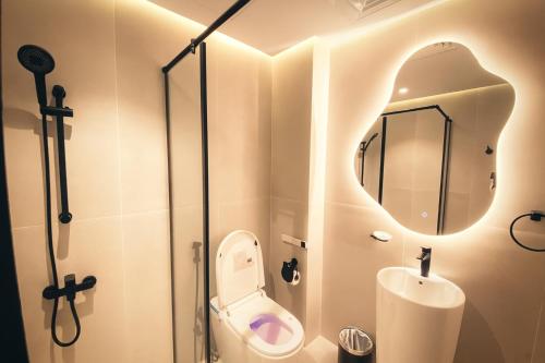 a bathroom with a toilet and a mirror at City Stay Dubai South - Serviced Apartments in Dubai