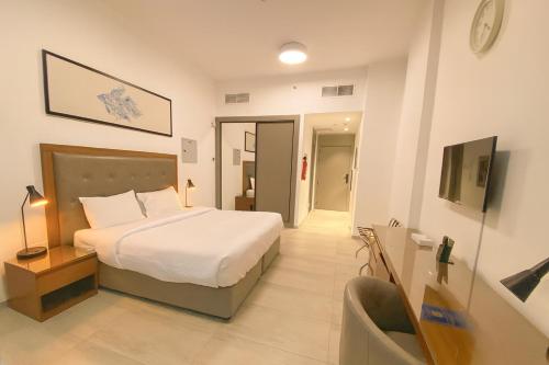 a bedroom with a bed and a chair in it at City Stay Dubai South - Serviced Apartments in Dubai