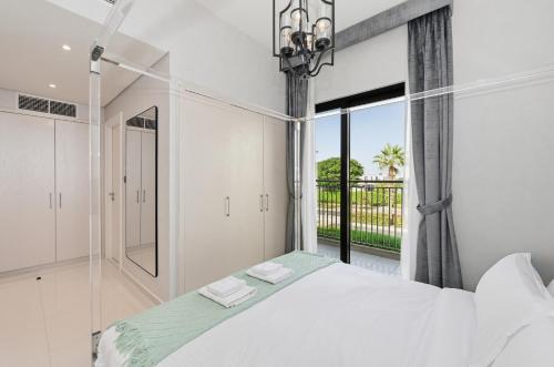 a bedroom with a white bed and a large window at 3BR Luxurious Villa pool view DAMAC Hills 2 in Dubai