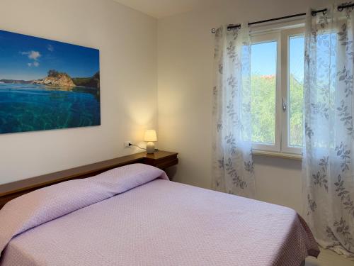 a bedroom with a bed and a large window at La Dimora di Bagnaja - HelloElba in Bagnaia
