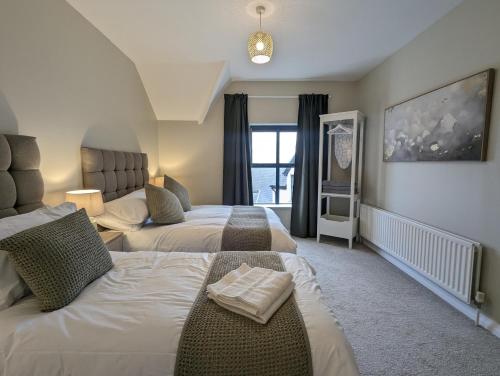 een hotelkamer met twee bedden en een raam bij Waterfoot Penthouse Apartment in Newcastle