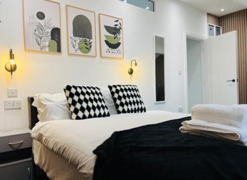 ein Schlafzimmer mit einem Bett mit schwarzen und weißen Kissen in der Unterkunft Yastayzzz at Apartment 4 Worcester House in Worcester