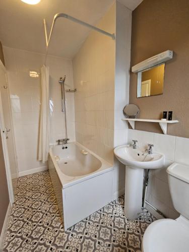 Un baño con bañera, lavabo e inodoro. en Rivelyn Hotel Bar & Restaurant, en Scarborough