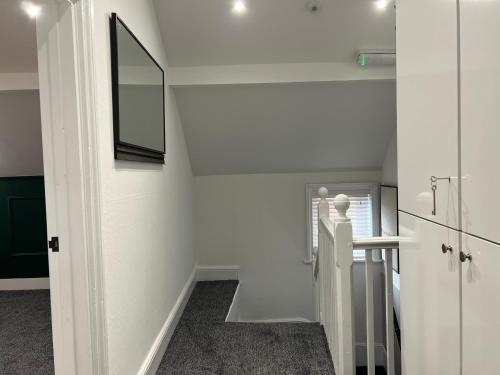 ein weißer Flur mit Spiegel und Treppe in der Unterkunft Yastayzzz at Apartment 4 Worcester House in Worcester