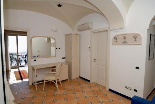 uma sala de jantar com uma mesa e um espelho em Hotel Bellevue Suite em Amalfi