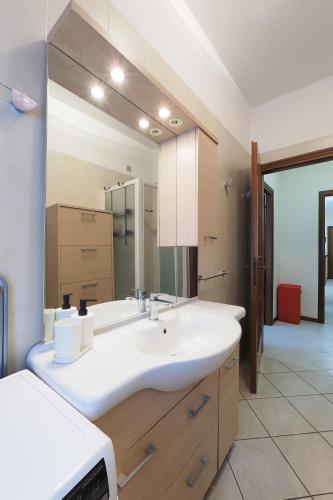 a bathroom with a sink and a large mirror at PrimoPiano - Don Gnocchi in Bresso