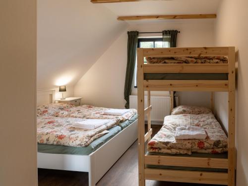Un dormitorio con dos literas y una ventana. en Chalupa Jesenka, en Sobotín