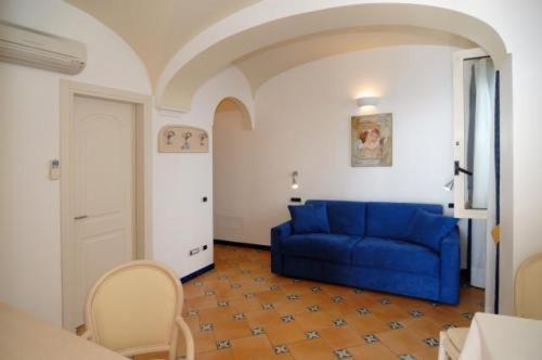 a living room with a blue couch in a room at Hotel Bellevue Suite in Amalfi