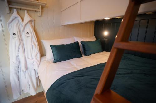 ein Etagenbett mit weißen Laken und grünen Kissen in der Unterkunft Friels Fairy Tree Hawthorn lodge in Swatragh