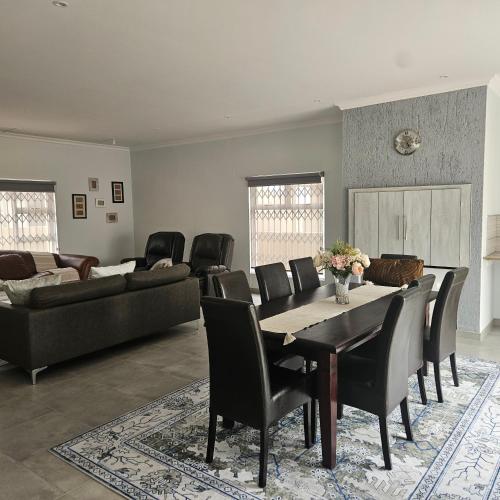 ein Wohnzimmer mit Tisch, Stühlen und Sofa in der Unterkunft Atlantis in Henties Bay