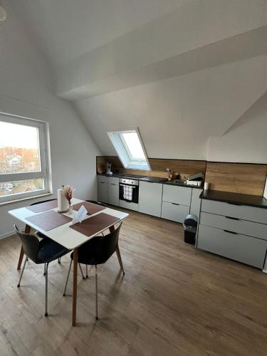 a living room with a table and a kitchen at Ferienwohnung Maichingen in Sindelfingen