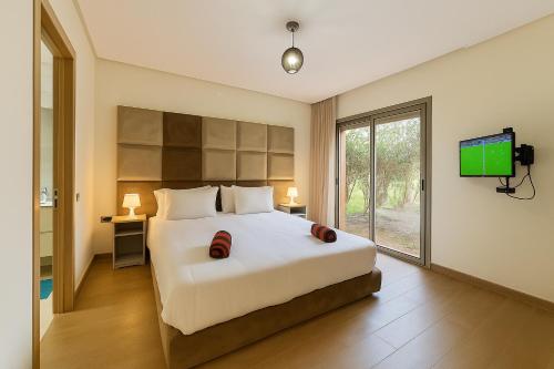 Ένα ή περισσότερα κρεβάτια σε δωμάτιο στο Marrakech Golf City PRESTIGIA