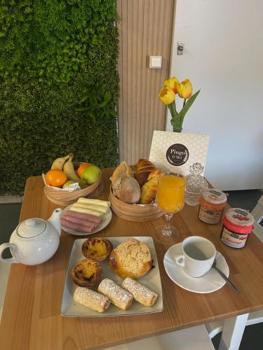 a table with a tray of breakfast foods and drinks at A Casa da Praça - The Square House in Miranda do Corvo