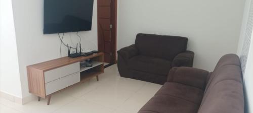 Una sala de estar con un sofá, una silla y un televisor. en Casa Lua, en Prado