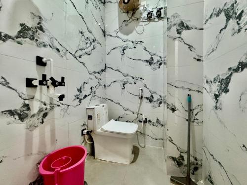 a black and white bathroom with a toilet and a bucket at Shree Hanumat Kripa Dham in Vrindāvan