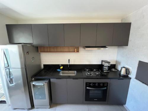 a kitchen with a sink and a refrigerator at 1 Dorm - Alto Padrão - 16 Andar - Home Office in Porto Alegre