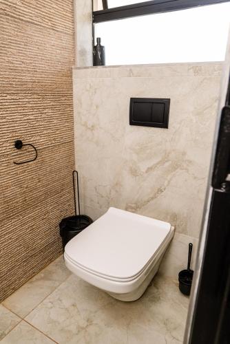 a white toilet in a bathroom with a shower at Villa On 59 in Giyani