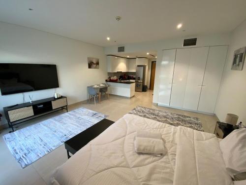 a bedroom with a large bed and a flat screen tv at Nuchi studio in Dubai