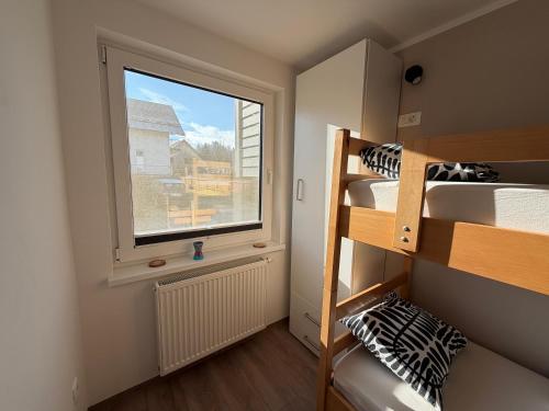 a small room with bunk beds and a window at Apartments Mici in Bled
