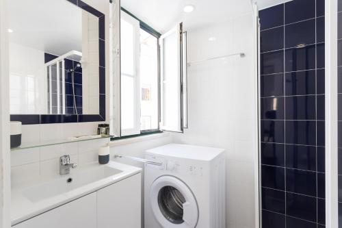 a white bathroom with a washing machine and a sink at Apartments Center Alfama in Lisbon
