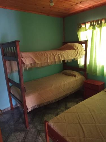 two bunk beds in a room with a green wall at Casa Aleluna in Villa Giardino