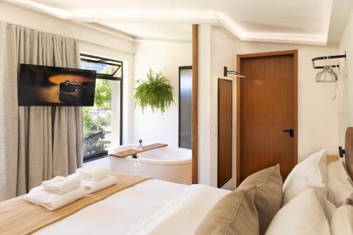 ein Schlafzimmer mit einem Bett und ein Badezimmer mit einem Waschbecken in der Unterkunft Monte Paraíso - banheira e vista da Pedra Menina in Espera Feliz