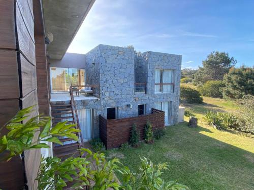 una casa costruita con un muro di pietra di Casa de Piedra Village del Faro a José Ignacio
